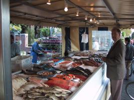 A well-dressed gentleman buys fish.