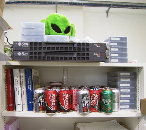 Unix manuals, DLT IV tapes,
soda pops, Suns, and an alien overseeing things.  Welcome to dannyman's work
area.