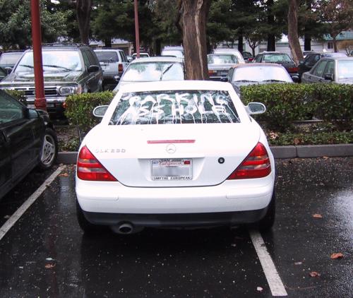White Mercedes with
"Parking Asshole" written in shoe polish on its back window.