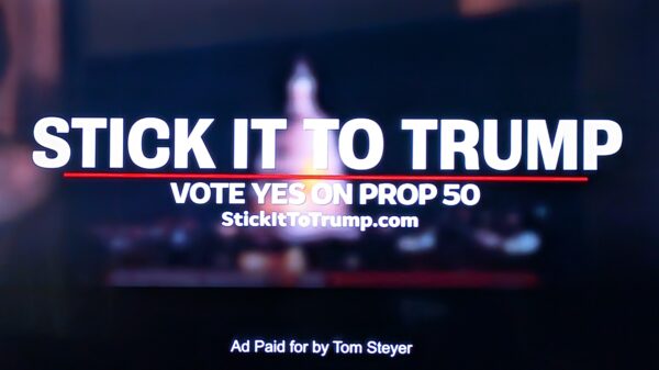 Still image of a TV commercial reads "Stick it to Trump / Vote Yes on Prop 50 / StickItToTrump.com / Ad Paid for by Tom Steyer"