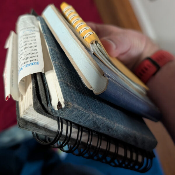 A stack of four small notebooks.