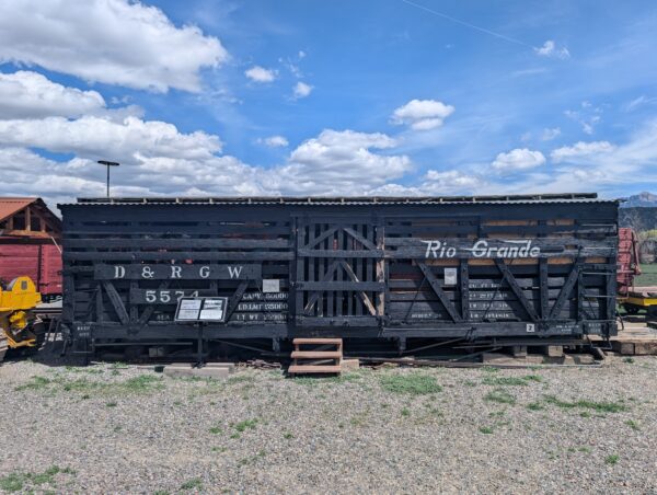 Old wooden stock car "D&RGW 5574" in black has clearly seen better days.