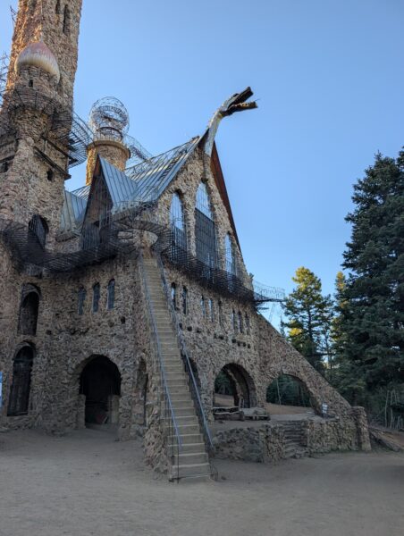 A rough stone structure, full of arches and stairways going way up high, a metal dragon atop.